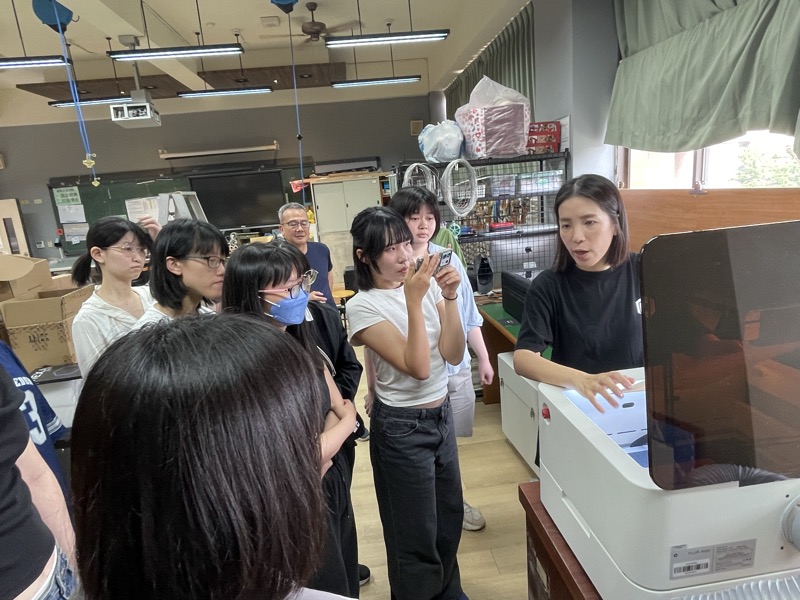 同學圍在 Ador 旁觀看示範