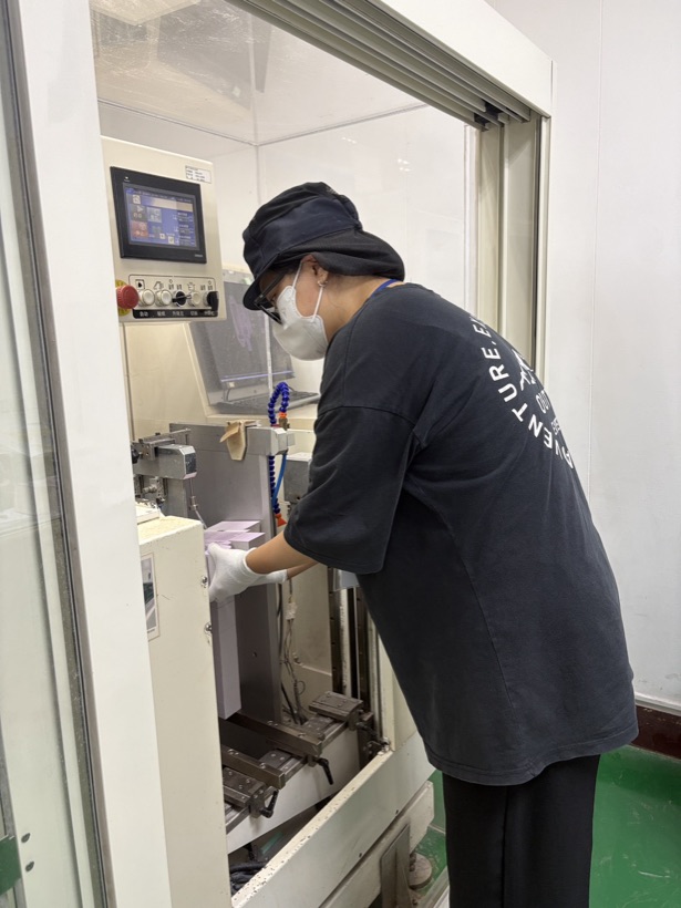 實習生操作品檢機台,檢測印刷完成的包裝