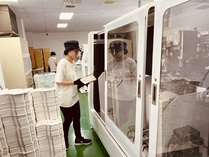 實習生在品檢區檢查包裝成品
