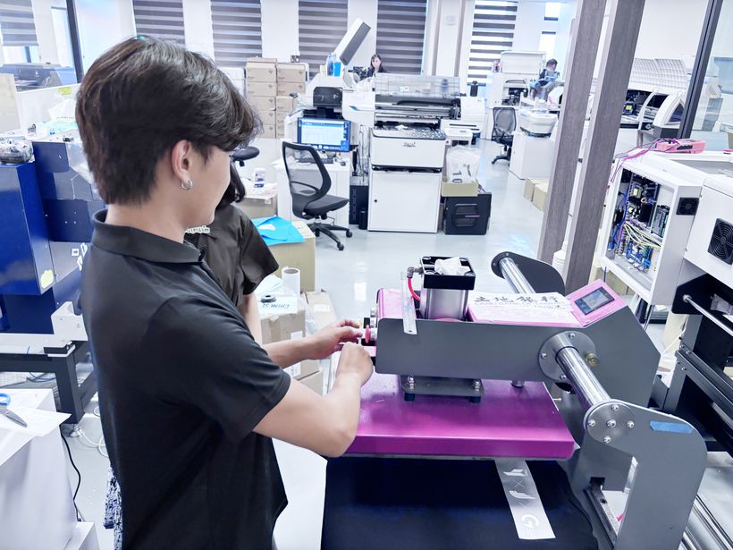 實習生操作燙印機,完成服飾圖樣轉印